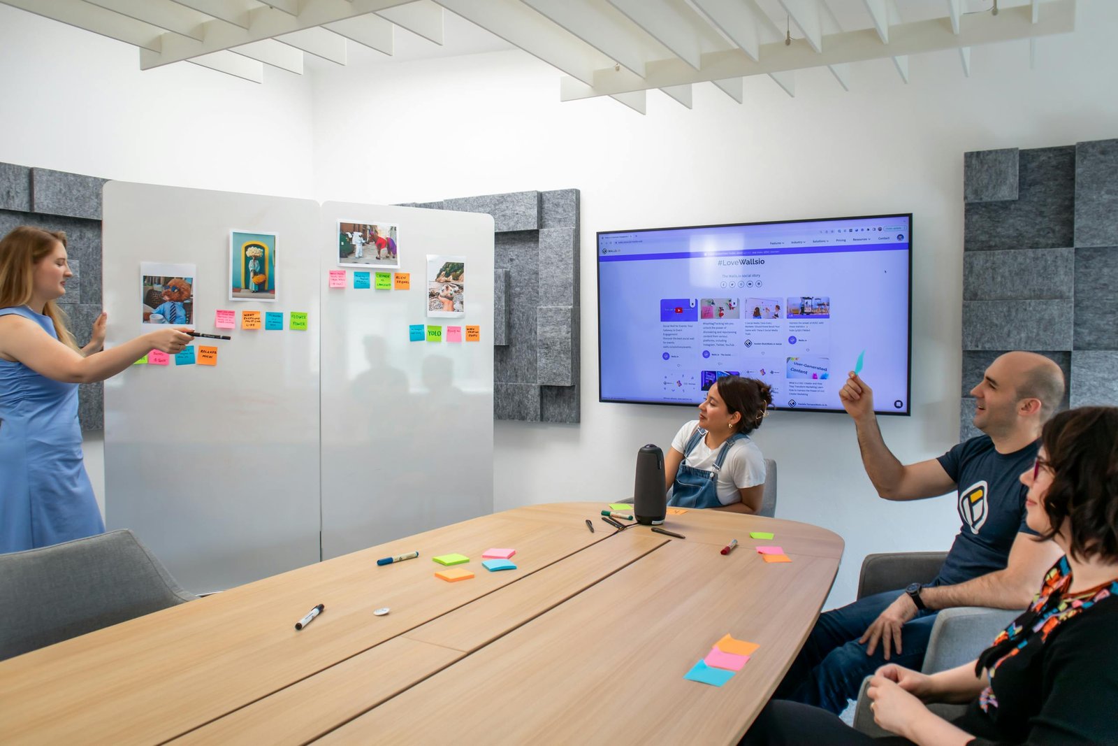 Scrum, Kanban ou SAFe : quelle méthode Agile choisir en 2026 ? 1 A group of coworkers engaged in a creative brainstorming session with colorful Post-it notes and a digital display.